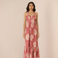 Woman wearing a pink floral dress against a beige background Calling June