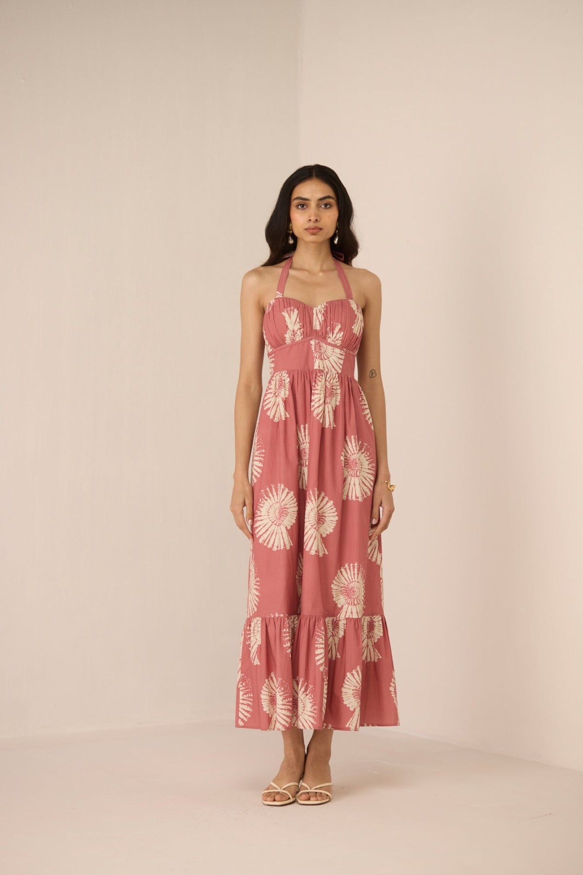 Woman wearing a pink floral dress against a beige background Calling June