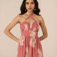Woman wearing a pink floral dress against a beige background Calling June