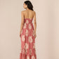 Woman wearing a pink floral dress against a beige background Calling June