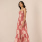Woman wearing a pink floral dress against a plain background Calling June