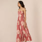 Woman wearing a pink strapless dress with white floral pattern on a beige background Calling June
