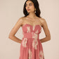 Woman wearing a strapless pink dress with floral patterns on a beige background Calling June