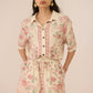 Woman wearing a floral romper against a plain background Calling June