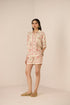Woman wearing a floral dress with a beige background Calling June