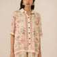 Woman wearing a floral outfit on a beige background Calling June