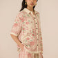 Woman wearing a floral outfit on a beige background Calling June