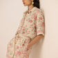 Woman wearing a floral outfit against a plain background Calling June