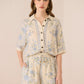 Woman wearing a floral outfit on a beige background Calling June