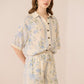 Woman wearing a floral outfit on a beige background Calling June