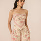 Woman wearing a floral romper on a beige background Calling June