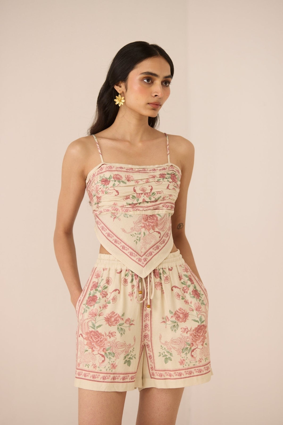 Woman wearing a floral romper on a beige background Calling June