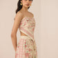 Woman wearing a floral two-piece outfit on a beige background Calling June