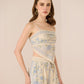 Woman wearing a floral dress and shorts on a beige background Calling June