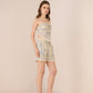 Woman wearing a patterned dress and shorts on a beige background Calling June