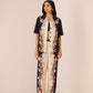 Woman wearing a black and white floral outfit on a beige background Calling June