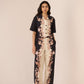 Woman wearing a black and white floral jumpsuit on a beige background Calling June