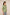 Woman wearing a green embroidered blouse against a beige background Calling June