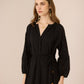 Woman wearing a black dress against a beige background Calling June