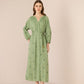 Woman wearing a green dress with floral patterns on a beige background Calling June