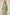 Woman wearing a green dress with floral embroidery against a beige background Calling June