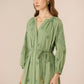 Woman wearing a green dress with floral patterns against a beige background Calling June