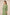 Woman wearing a green dress with floral patterns against a beige background Calling June