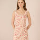 Woman wearing a floral dress against a beige background Calling June