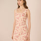 Woman wearing a floral dress against a plain background Calling June