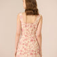 Woman wearing a floral dress against a beige background Calling June