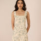 Woman wearing a floral dress against a beige background Calling June