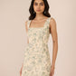 Woman wearing a floral dress against a plain background Calling June