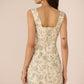 Woman wearing a floral dress with a beige background Calling June