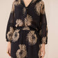 Woman wearing a black outfit with beige floral patterns on a beige background Calling June