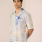 Man wearing a patterned shirt with starfish and shell designs on a plain background Calling June