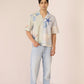 Man wearing a patterned shirt and jeans on a plain background Calling June