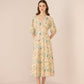 Woman wearing a floral dress against a plain background Calling June