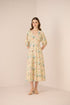 Woman wearing a floral dress against a plain background Calling June