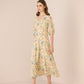 Woman wearing a floral dress against a plain background Calling June