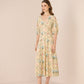 Woman wearing a floral dress against a plain background Calling June