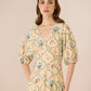 Woman wearing a floral dress against a beige background Calling June