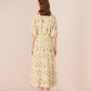 Woman wearing a floral dress on a beige background Calling June