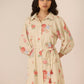Woman wearing a floral dress with a beige background Calling June