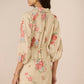 Woman wearing a floral dress with a beige background Calling June