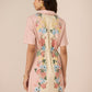 Woman wearing a floral dress with a plain background Calling June