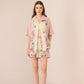 Woman wearing a floral dress with a matching jacket on a beige background Calling June