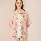 Woman wearing a pink floral outfit on a beige background Calling June