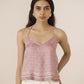 Woman wearing a pink patterned top against a beige background Calling June