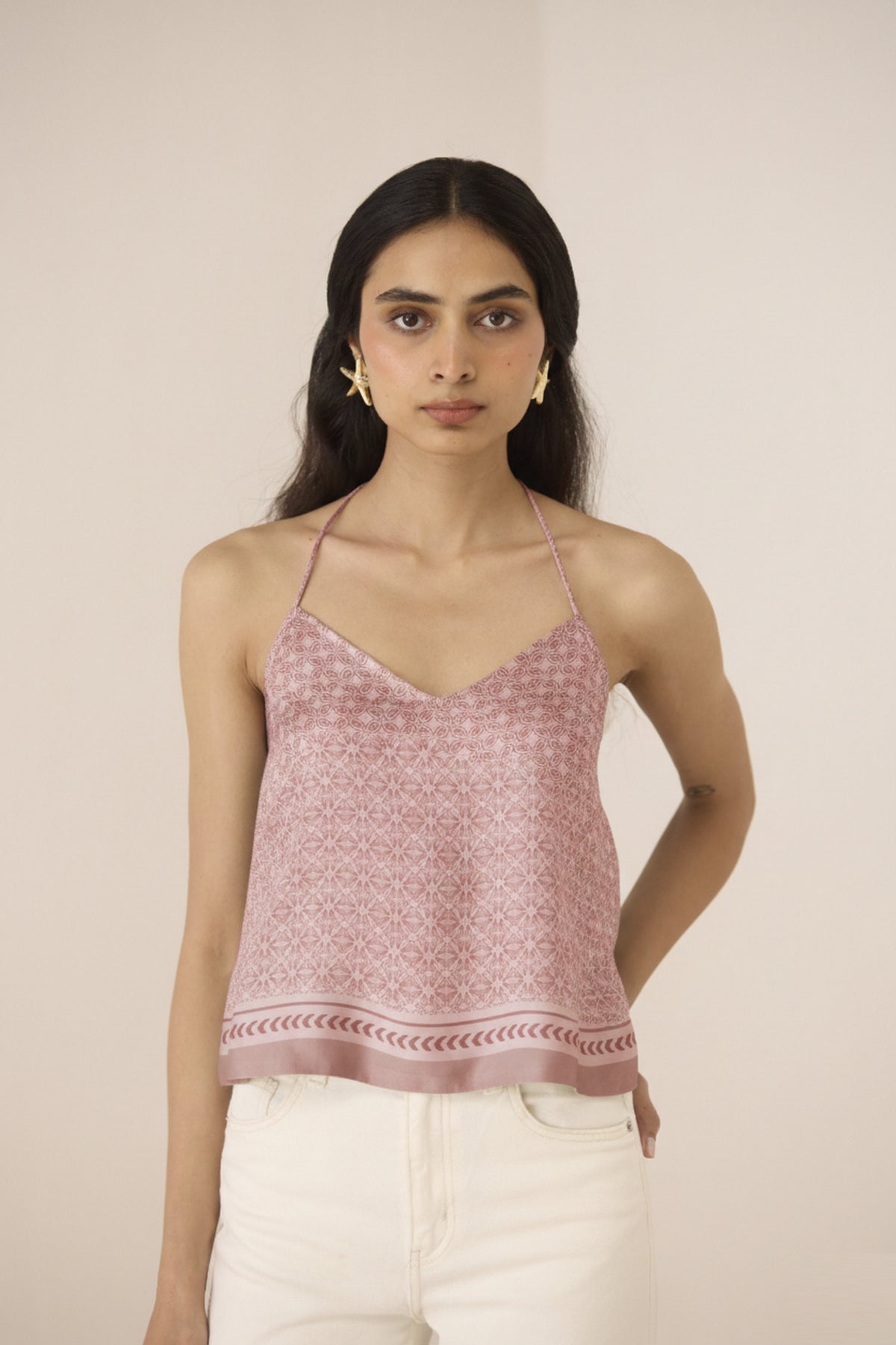 Woman wearing a pink patterned top against a beige background Calling June