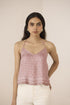 Woman wearing a pink patterned top against a beige background Calling June